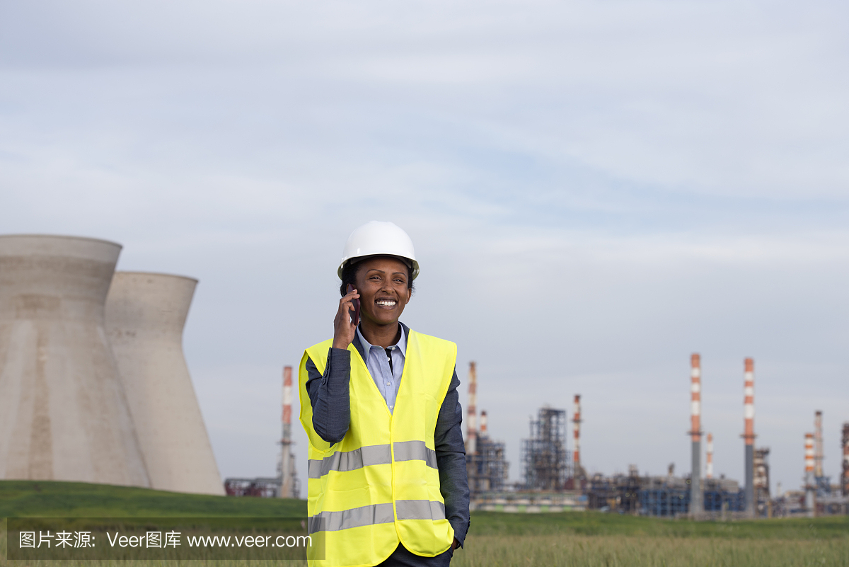 在化工廠打電話的女商人。